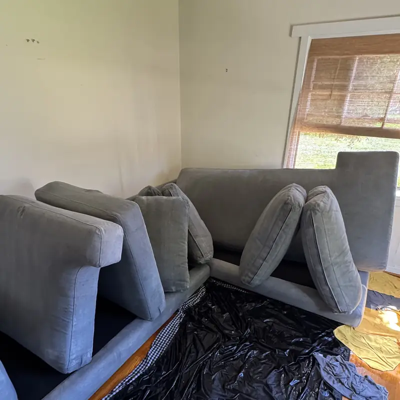 Gray sectional with cushions removed and floor protected during cleaning